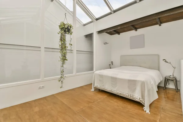a bedroom with wood floors and skylights on the ceiling, as seen from the bed in the corner of the room is white