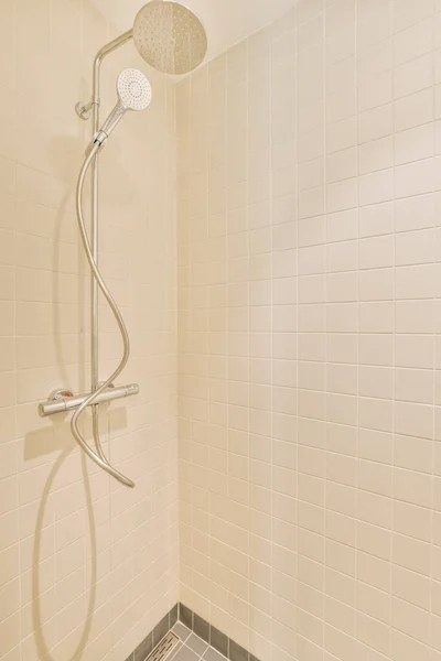 浴室の壁に白いタイルとグレーのタイルの床のシャワーが表示されます — ストック写真