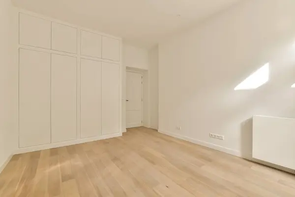Пустая Комната Деревянными Полами Белыми Шкафами Стене Справа Одной Двери — стоковое фото