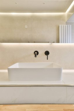 Ahşap döşemeleri ve beyaz duvarları olan modern bir banyo.