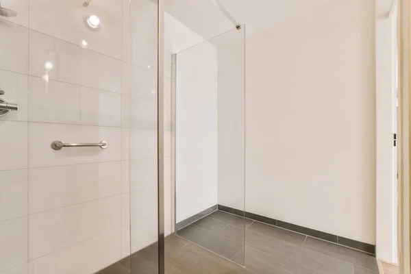 带有白色墙壁和灰色地板的浴室 包括房间中央的淋浴间 — 图库照片