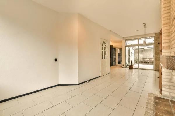 stock image an empty living room with white walls and floor tiles on the floor, there is a fireplace in the corner