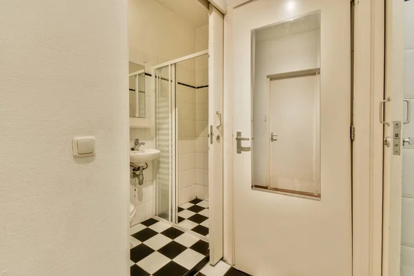 Łazienka Czarno Białymi Płytkami Kratkę Podłodze Przed Drzwiami Kabiny Prysznicowej — Zdjęcie stockowe