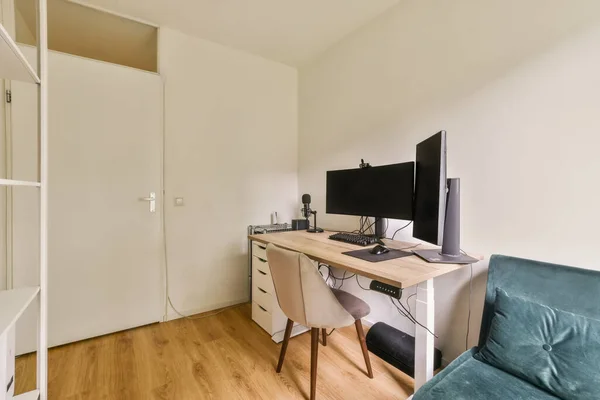 Mały Pokój Biurkiem Krzesłem Monitorem Komputerowym Ścianie Nim Jest Białe — Zdjęcie stockowe
