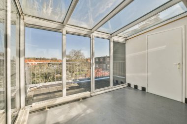 Büyük pencereli ve şehir manzaralı bir oda. Açık havalandırma ünitesinin içinden alındı.