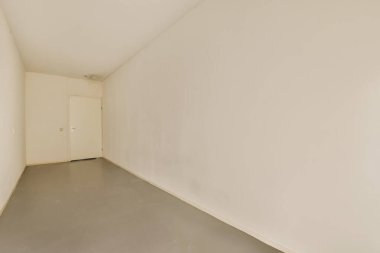 Beyaz duvarları olan boş bir oda. Köşede durup diğer duvara bakan kimse yok.