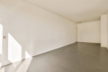 Pencereden içeri ışık giren boş bir oda ve arkasında gölgeler olan yukarıdan alınan bir oda.