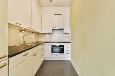 a kitchen with white cupboards and black counter tops on the counters in this is an example of modern design