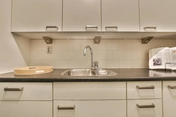 Eine Küche Mit Weißen Schränken Und Schwarzen Arbeitsplatten Der Wand — Stockfoto