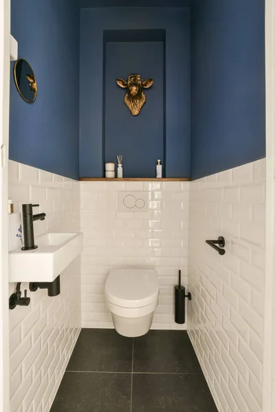 有蓝色墙壁和白色瓷砖的小浴室在水池前面有一个厕所 — 图库照片