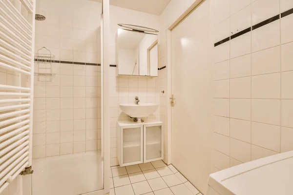Een Kleine Badkamer Met Witte Tegels Zwarte Bekleding Rond Het — Stockfoto