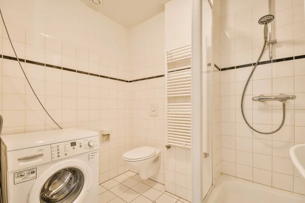 구석에 세탁기와 건조기가 오른쪽에 샤워실 — 스톡 사진