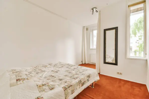 Sypialnia Pomarańczowym Dywanem Łóżkiem Przed Białą Ścianą Ścianie Wisi Duże — Zdjęcie stockowe