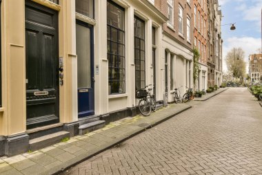 Kenarında bisikletleri ve arka tarafında binaları olan kaldırımdan görüldüğü gibi kaldırımlı bir cadde.