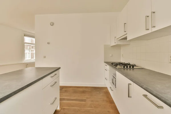 Eine Küche Mit Weißen Schränken Und Schwarzen Arbeitsplatten Auf Den — Stockfoto