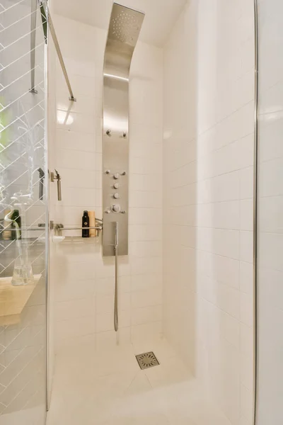 这张照片中的浴室是一个现代化的浴室 有白色的瓷墙和地板 还有淋浴间的门 — 图库照片
