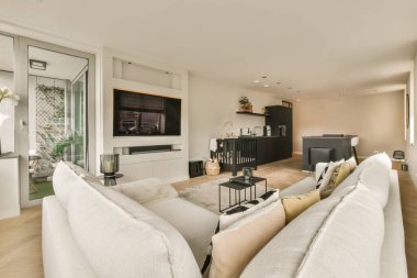 Odadaki duvarda iki kanepesi ve düz ekran televizyonu olan bir oturma odası çok temiz.