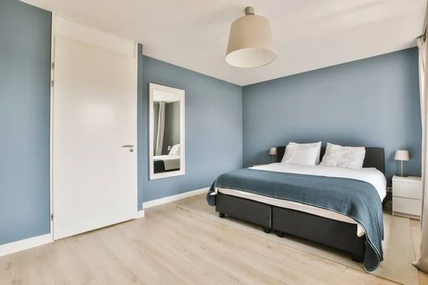 Ett Sovrum Med Blå Väggar Och Vit Kant Runt Sängen — Stockfoto