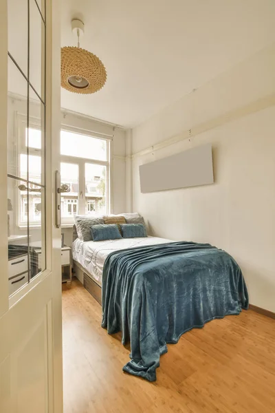 Dormitorio Con Suelo Madera Una Manta Azul Cama Frente Puerta — Foto de Stock