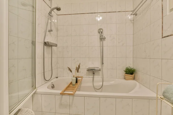 在地板上有白色瓷墙和大理石瓦的小浴室 旁边有一个浴缸 — 图库照片