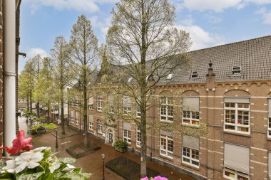 an apartment in the netherlands with flowers and trees on either side, looking out onto one of the courtyards