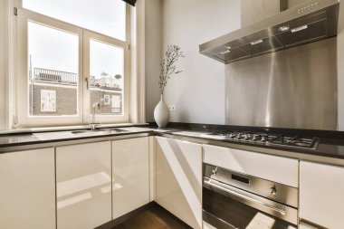 a modern kitchen with white cabinets and black counter tops in the center of the image is an open window overlooking city view