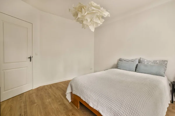 白い壁と木の床があるベッドルームは清潔でお客様もご利用いただけます — ストック写真