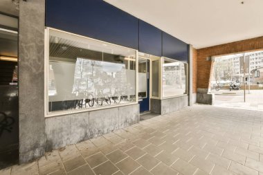 Bir dükkanın önündeki duvarda boş kaldırımlı ve sağa doğru tuğlalı bir alan olan bir bisiklet.