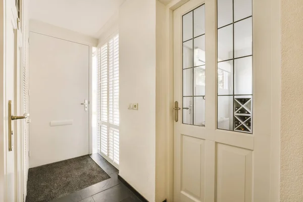 房间里的一扇白色门 后面有黑色的瓷砖地板 墙上有木制百叶窗 是一面大镜子 — 图库照片