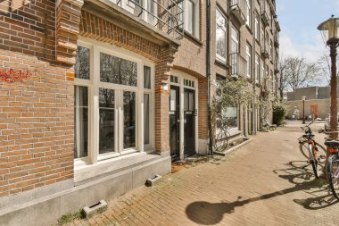 Sokak kenarındaki tuğladan bir binanın önüne park edilmiş bir bisiklet. Postanenin yanına.