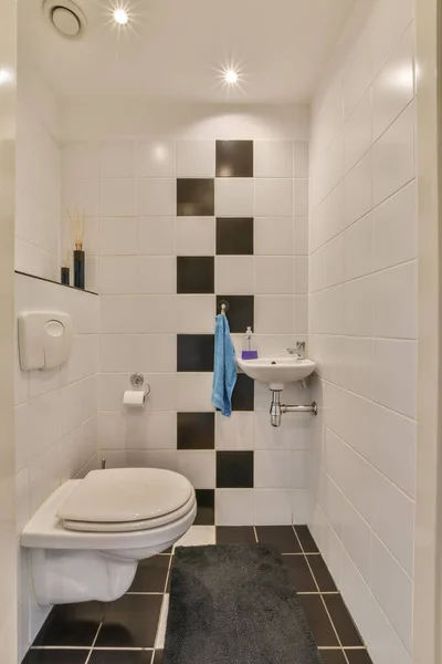Mała Łazienka Czarno Białymi Płytkami Ścianach Wraz Toaletą Centrum Pokoju — Zdjęcie stockowe
