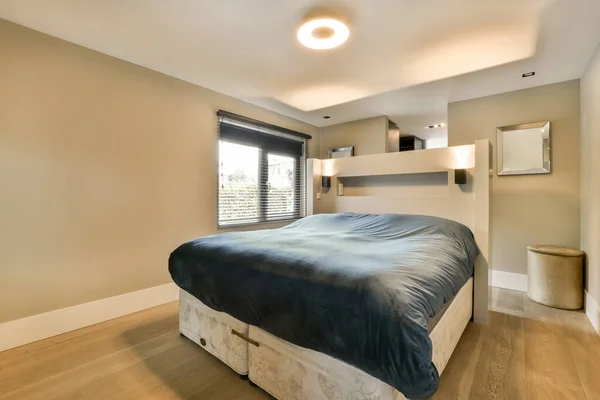 有木制地板和白色墙壁的卧室 包括房间里床上的蓝色垫子 — 图库照片