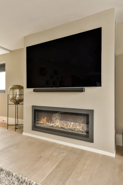 a living room with a flat screen tv on the wall, and a fireplace in the corner of the room
