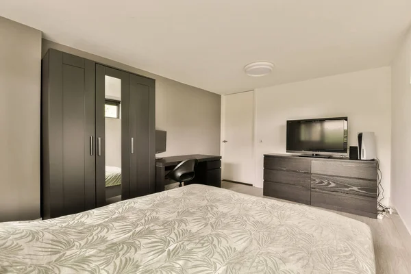 在床前有一张床 梳妆台和电视的旅馆房间是深色的木头 — 图库照片