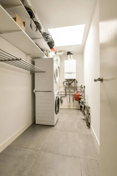 洗衣房 前面墙上挂着洗衣机 烘干机和其他物品 — 图库照片
