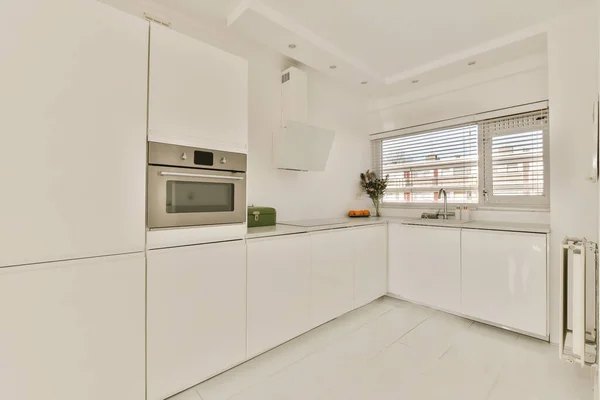 アパート開発 メルボルン ビクトリア オーストラリアのカウンタートップに白いカップボードと電化製品を備えたキッチン — ストック写真