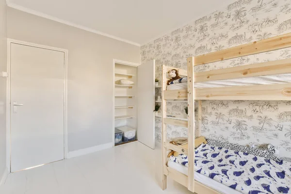 2つの二段ベッドとベッドの後ろに壁紙のクローゼットがある子供部屋は開いたドアです — ストック写真