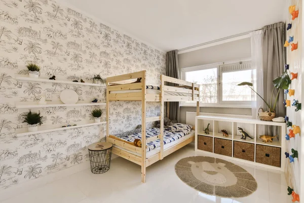 2つの二段ベッドと窓の間のコーナーに壁に貼られたエリアを持つ子供部屋 — ストック写真