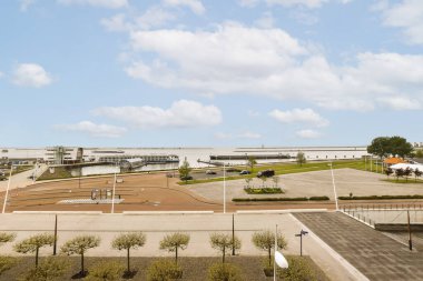 Boş bir otopark. Arabalar yan tarafta ve binalar arka tarafta. Yukarıdan çekiliyor.