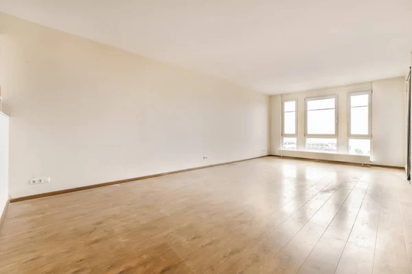 部屋には木の床と白い壁がある空のリビングルームはとても綺麗ですが家具はありません — ストック写真