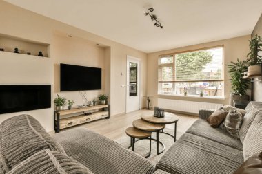 Odadaki duvarda iki kanepesi ve düz ekran televizyonu olan bir oturma odası çok temiz.