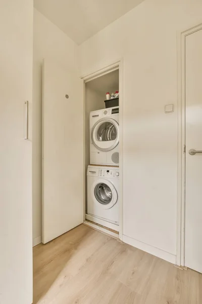 a laundry room with a washer and dryer in the corner door is open on the right hand side