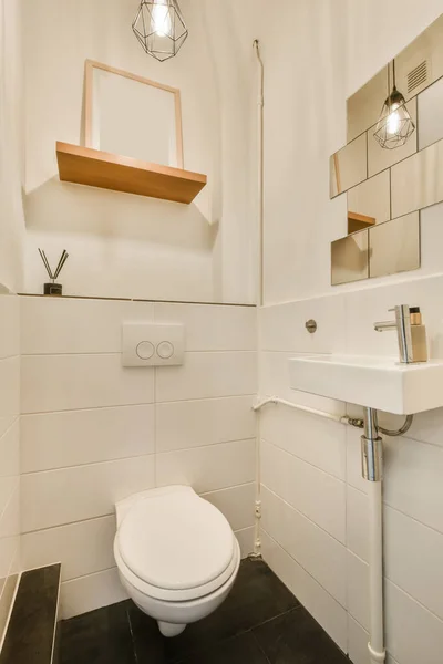 Łazienka Białą Toaletą Czarnymi Płytkami Podłodze Obok Lustra Nad Nią — Zdjęcie stockowe