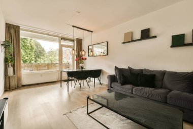 Oturma odası, bir kanepe, bir sehpa ve pencerenin önünde televizyon.