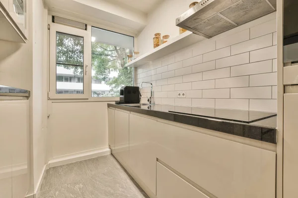 Uma Cozinha Com Azulejos Brancos Nas Paredes Contra Espaço Frente — Fotografia de Stock