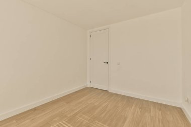 Beyaz duvarları ve ahşap döşemeleri olan boş bir oda. Odanın sağ tarafı açık.