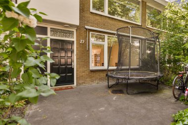 Garaj yoluna parketmiş bisikletli bir ev ve güneşli bir günde kapının üzerinde bir şemsiye açık.