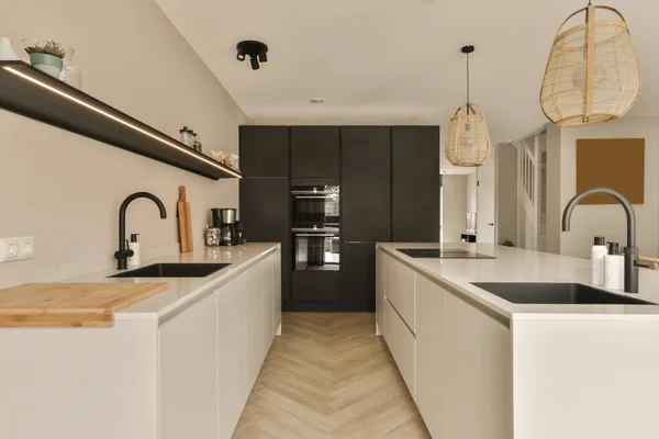 a modern kitchen with black and white cabinets, wood flooring and an island bench in the center of the room