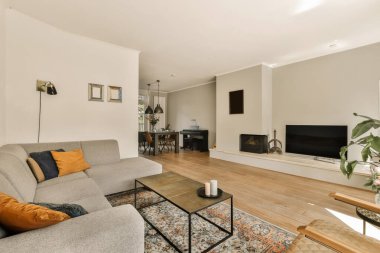 Oturma odası, kanepe, sehpa ve odanın duvarında televizyon çok temiz.