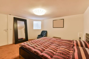 Sağ köşesindeki duvarda yatak odası, sandalye ve ayna var.